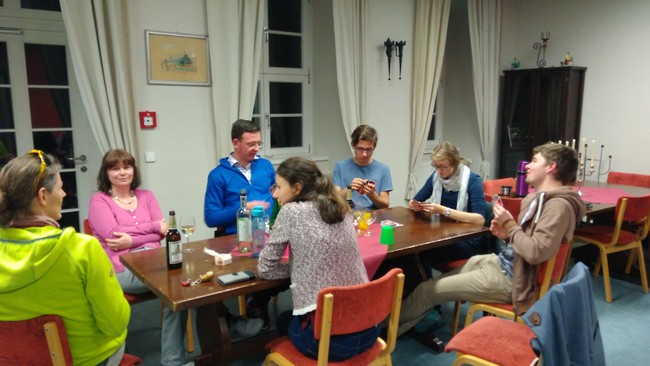 Chormitglieder sitzen an einem Tisch und spielen Karten
